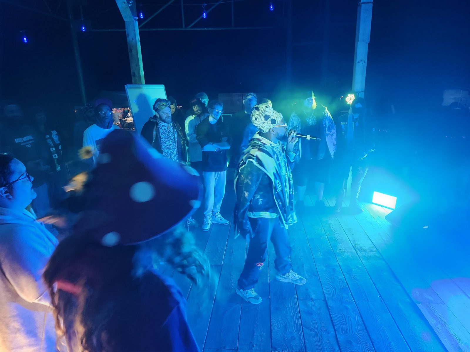 Emcees on the stage under blue light at night