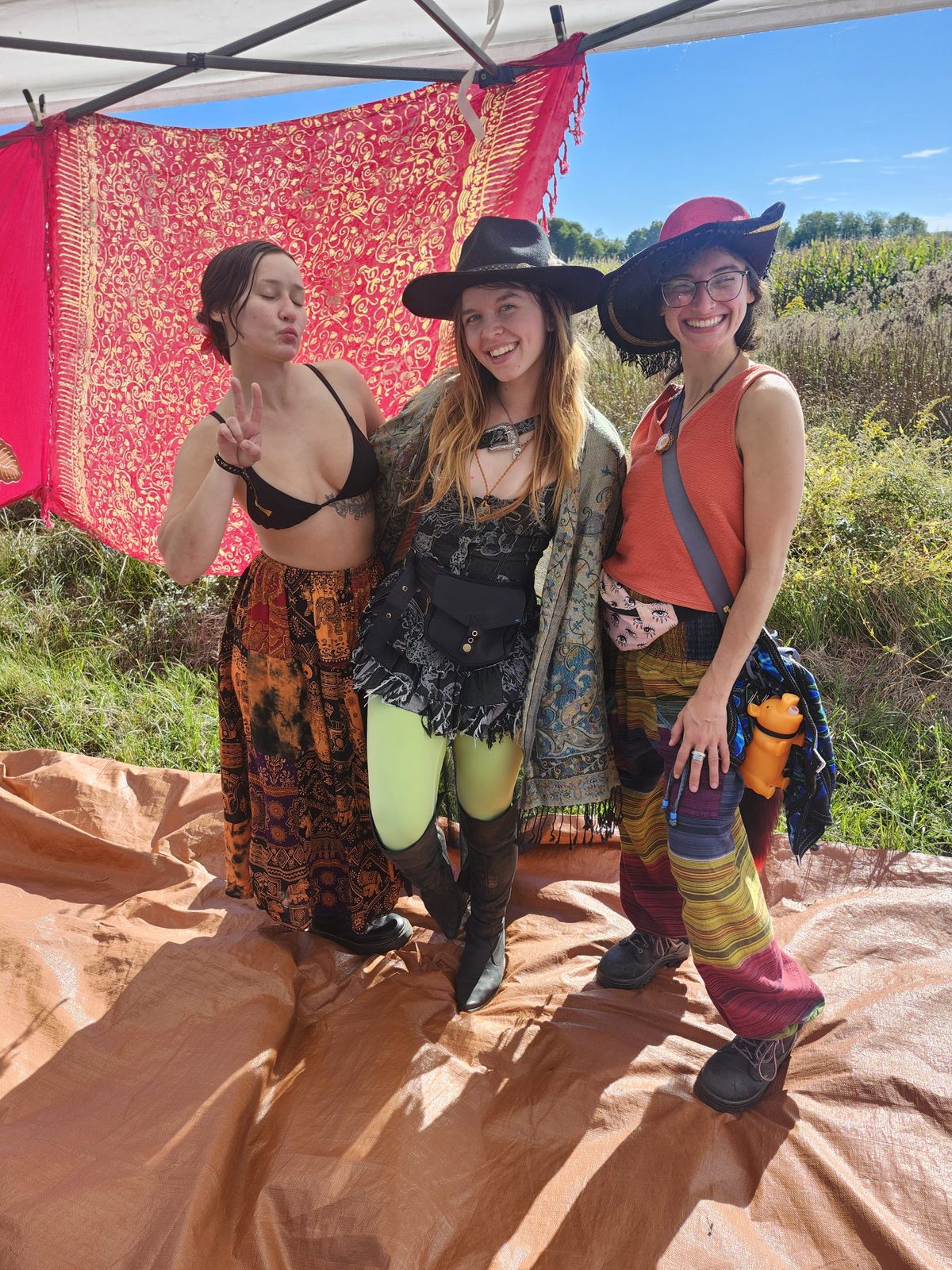 Three friends posing under the canopy