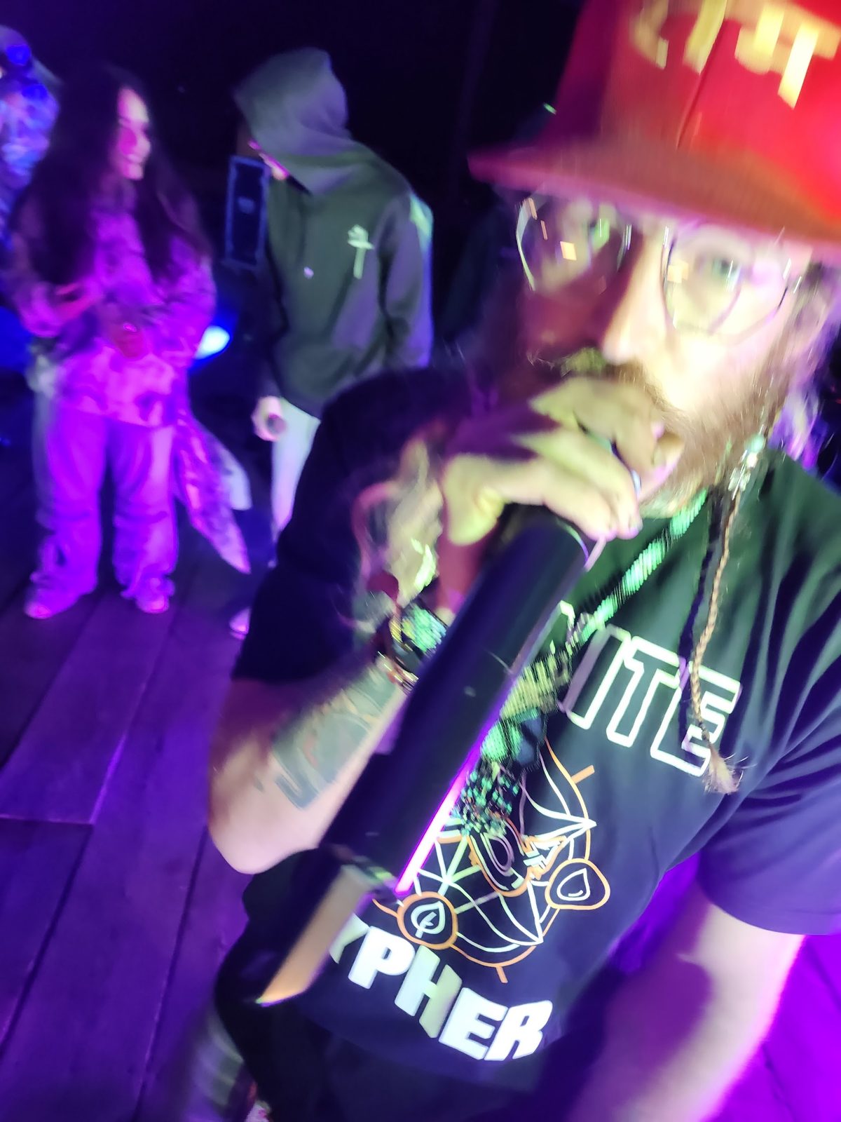 An emcee on the mic under purple stage light