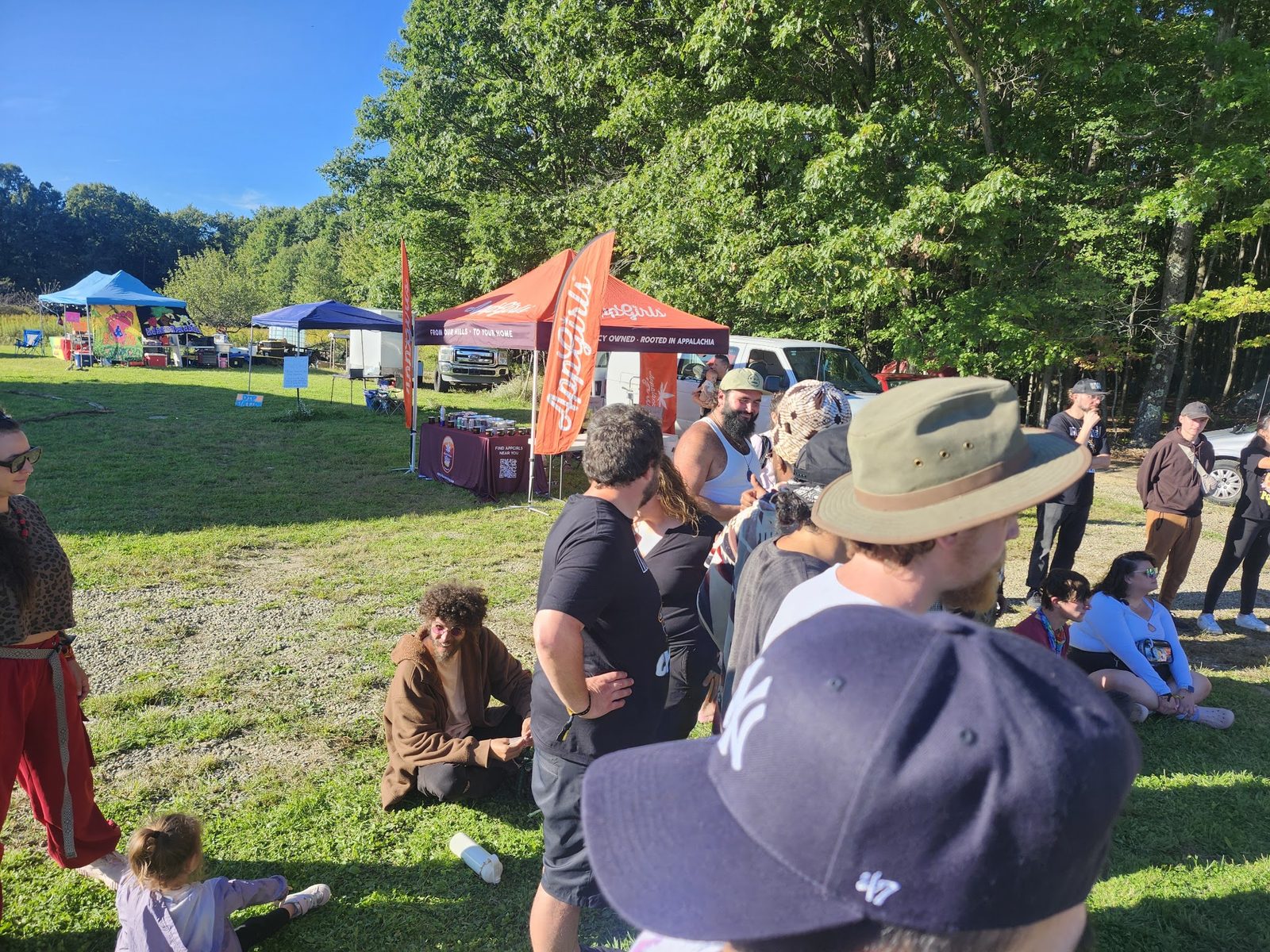 The crowd on the grass with tents behind