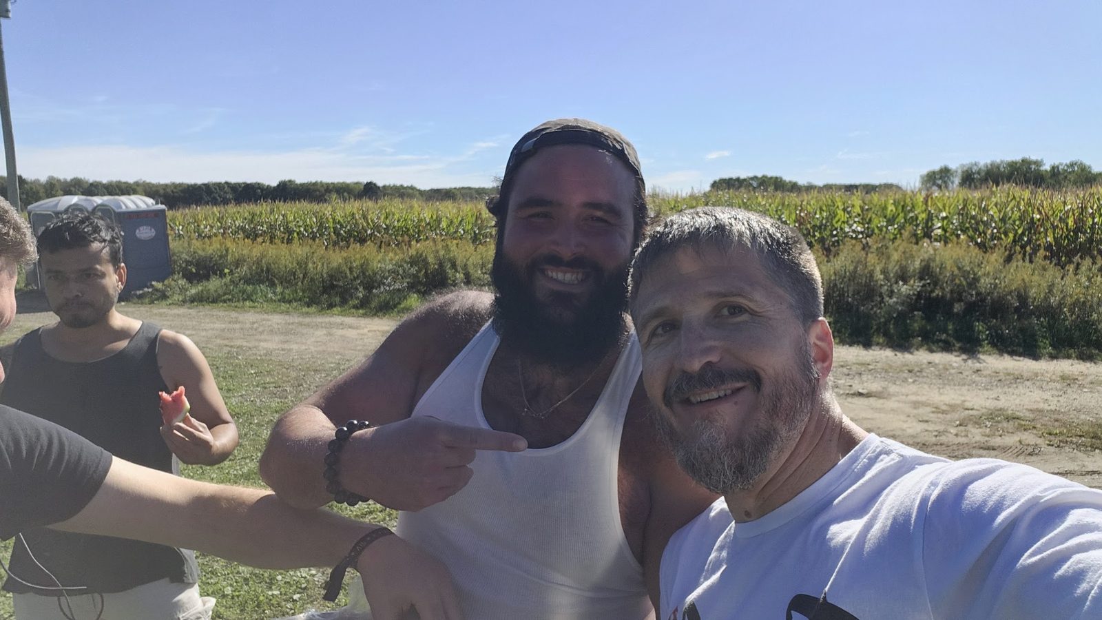 Three friends in the field at the edge of the corn